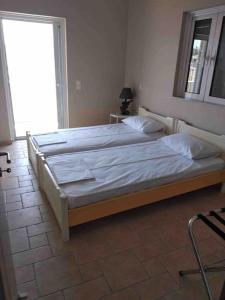 two twin beds in a room with a window at Villa Petries Relaxed Holidays in Áyioi Apóstoloi