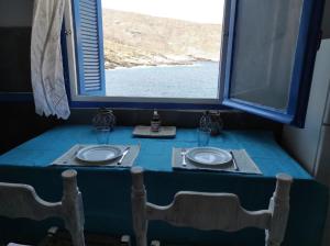 a blue table with two plates and a window at Malli Sea House in Mamádhos +24 photos