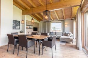 een eetkamer en een woonkamer met een tafel en stoelen bij Chalet 149 Westendorf by ALPS RESORTS in Westendorf