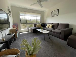 a living room with a couch and a table at Family Holiday Vibe House in Dakabin in Dakabin