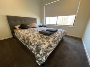 a bedroom with a large bed with a large window at Family Holiday Vibe House in Dakabin in Dakabin
