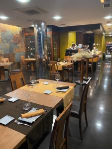 restauracja z drewnianymi stołami i krzesłami w pokoju w obiekcie O SECRETO w mieście Padrón