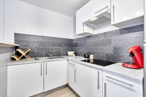 a kitchen with white cabinets and a red appliance on the counter at OFFRE SPECIALE Centre Verdun - Idéal Famille - Le Châtelois in Verdun-sur-Meuse