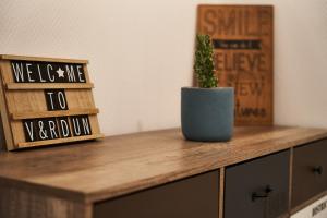 a plant in a blue pot on a wooden dresser at OFFRE SPECIALE Centre Verdun - Idéal Famille - Le Châtelois in Verdun-sur-Meuse