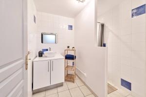 a white bathroom with a sink and a mirror at OFFRE SPECIALE Centre Verdun - Idéal Famille - Le Châtelois in Verdun-sur-Meuse
