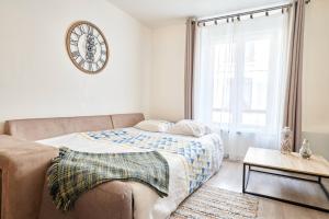 1 dormitorio con 1 cama y reloj en la pared en OFFRE SPECIALE Centre Verdun - Idéal Famille - Le Châtelois, en Verdún
