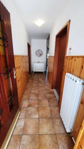 pasillo con puertas de madera y suelo de baldosa en Apartma Bajc, en Sečovlje