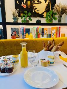 una mesa con un plato de comida y una botella de zumo en La bohème - Chambres d’hôtes, en Senlis