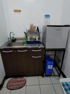 a small kitchen with a sink and a refrigerator at Ilia's Cozy Abode near Enchanted Kingdom & Nuvali in Santa Rosa