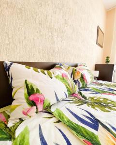 uma cama com um edredão colorido e almofadas em Blue Sky Apartments em Nesebar