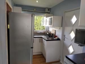 a small kitchen with a refrigerator and a sink at Self Catering Studio in Juniper Green