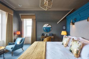 ein Schlafzimmer mit einem großen Bett und einer blauen Wand in der Unterkunft No17 The Promenade in Oban