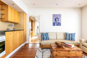 una sala de estar con un sofá y una mesa en Camps Bay Village - Village Apartments, en Ciudad del Cabo