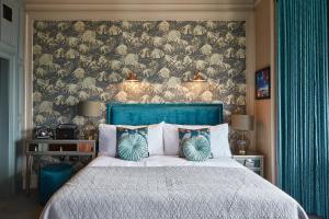 a bedroom with a large bed with a blue headboard at No17 The Promenade in Oban