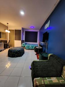 uma sala de estar com um sofá e uma parede azul em Chichi's Snug Pad near Enchanted Kingdom and Nuvali em Santa Rosa