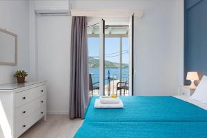 a bedroom with a blue bed and a balcony at Marika Apartments in Kassiopi