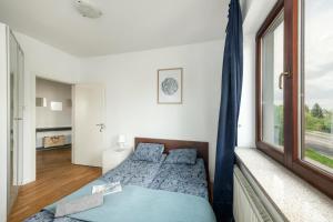 Schlafzimmer mit einem Bett und einem Fenster in der Unterkunft Waw pokoje Wilanów in Warschau