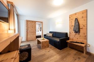 カルテルベッロにあるHotel Sandの木製の壁のリビングルーム(黒いソファ付)
