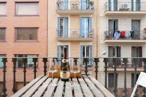 una mesa de madera con copas de vino en el balcón en ApartEasy - Turo Park with lovely balcony en Barcelona