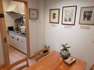 a dining room with a table and a kitchen at Deer hostel-外国人予約限定 in Nara