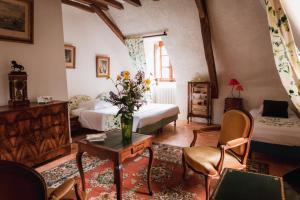 een woonkamer met 2 bedden en een tafel met bloemen bij Château du Plessis - Anjou in La Jaille-Yvon