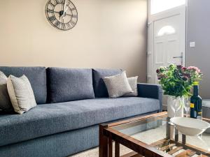 a blue couch in a living room with a glass table at Maple House - Free Parking - Holiday Home - Sleeps 12 With Sister Property in York