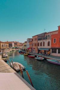 eine Gruppe von Booten in einem Kanal mit Gebäuden in der Unterkunft Simone Cenedese Murano Apartments - Ambra in Venedig