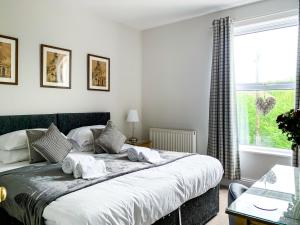 a bedroom with a large bed and a window at Maple House - Free Parking - Holiday Home - Sleeps 12 With Sister Property in York