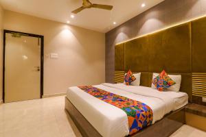 a bedroom with a large bed and a ceiling at FabHotel Maya Crystal in Kānpur