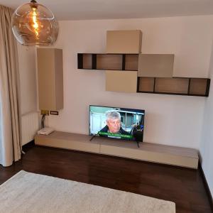 オトペニにあるWhite Galaxy Villaの壁に薄型テレビが取り付けられたリビングルーム