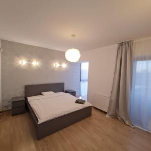 een slaapkamer met een bed en een groot raam bij White Galaxy Villa in Otopeni