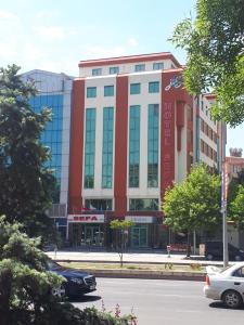 un edificio rojo y blanco con coches estacionados frente a él en SEFA HOTEL 1 ÇORLU, en Çorlu