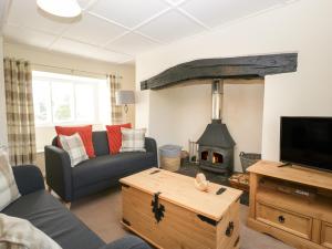 a living room with a couch and a fireplace at 2 Court Farm in Wareham