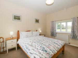 a bedroom with a bed and a window at 2 Court Farm in Wareham