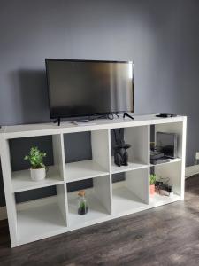 un centro di intrattenimento bianco con una TV a schermo piatto di Un bel appartement proche centre ville et 20 mn du Puy du Fou a Cholet