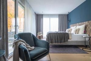 a bedroom with a bed and a chair and a bed at Hotel Garni Villa Rosengarten in Überlingen