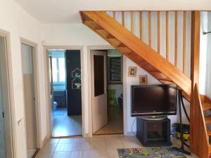 sala de estar con escalera y TV de pantalla plana en Pool house, en Balatonkenese