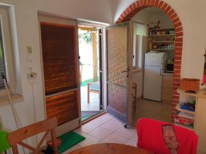a kitchen with a door open to a kitchen with a refrigerator at Pool house in Balatonkenese