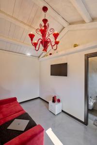 Habitación con cama roja y lámpara de araña. en Simone Cenedese Murano Apartments - Ambra, en Venecia