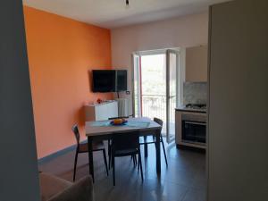 cocina con mesa y sillas en una habitación en Appartamenti Antico Uliveto, en Soverato Superiore