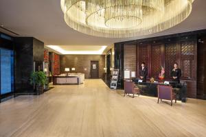 un vestíbulo de un hotel con una gran lámpara de araña en Somerset Grand Central Dalian en Dalian