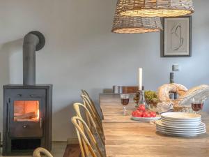 a dining room with a table with a wood stove at traumHaff Summer by Sea mit Kamin, privates NORDICSPA, Boot in Rieth