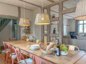 a dining room with a wooden table with chairs and lights at traumHaff Summer by Sea mit Kamin, privates NORDICSPA, Boot in Rieth
