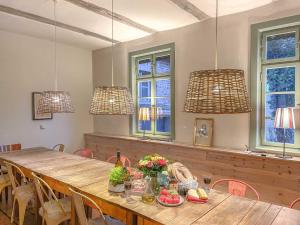 a dining room with a wooden table and three lights at traumHaff Summer by Sea mit Kamin, privates NORDICSPA, Boot in Rieth