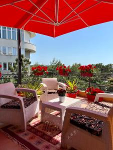 un patio con mesa, sillas y sombrilla en Don Robert Apartment en Durrës