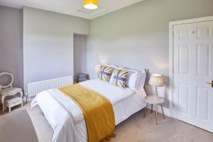Host & Stay - Ramblers Rest Cottage في Greenhead: غرفة نوم بسرير وبطانية صفراء