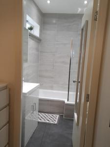 Baño blanco con bañera y lavamanos en Star London Brent Street Cosy 1-Bed Hideaway, en Hendon