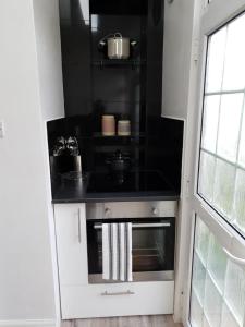 a kitchen with a stove and a black counter top at Star London Brent Street Cosy 1-Bed Hideaway in Hendon