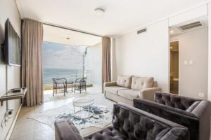 een woonkamer met een bank en uitzicht op de oceaan bij Durban Point Waterfront, 1006 Quayside in Durban