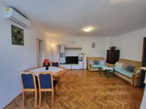 uma sala de estar com uma mesa e um sofá em Salkić Apartman em Fažana